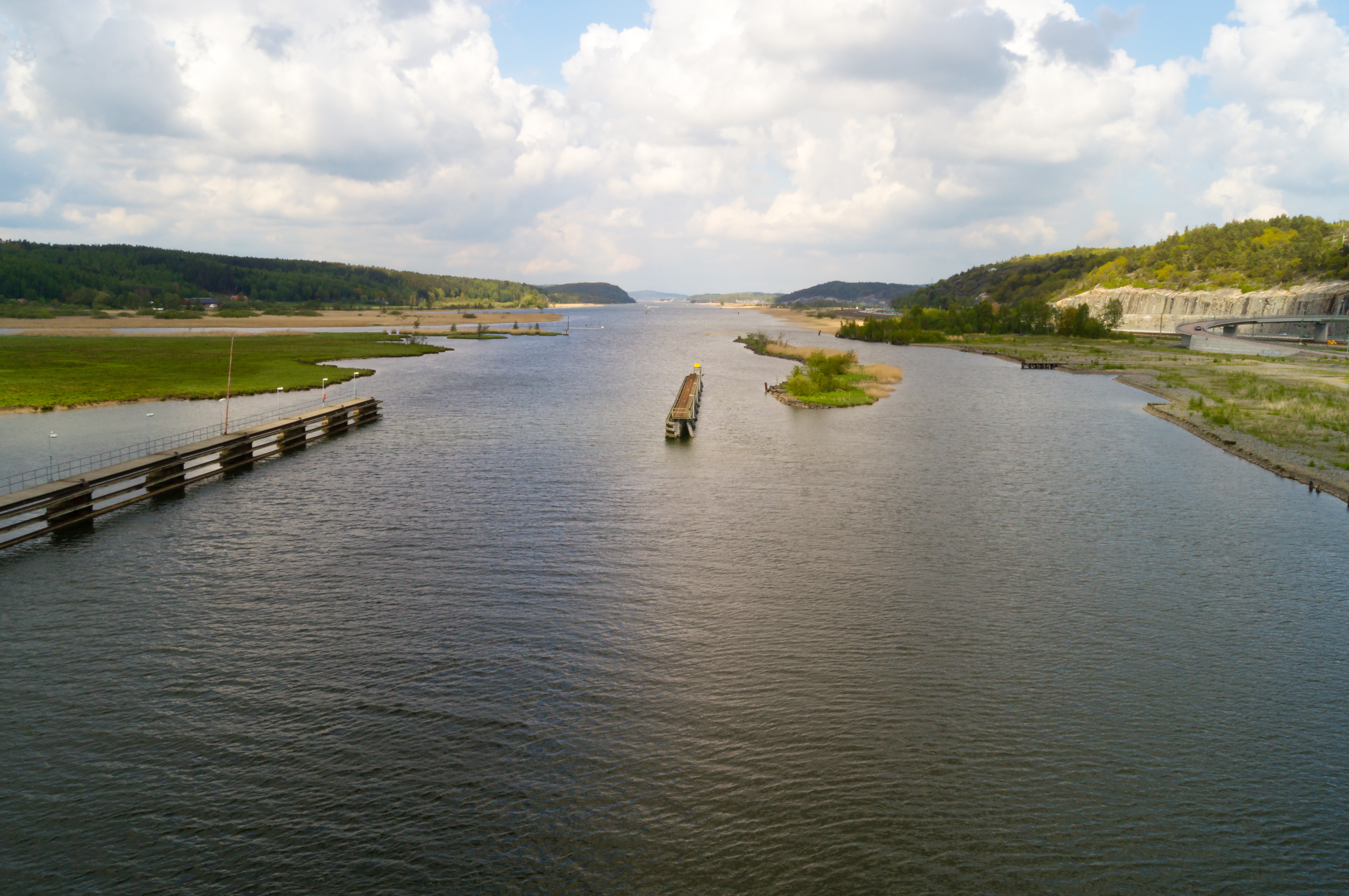 En båt som färdas nedför en flod bredvid en bro
