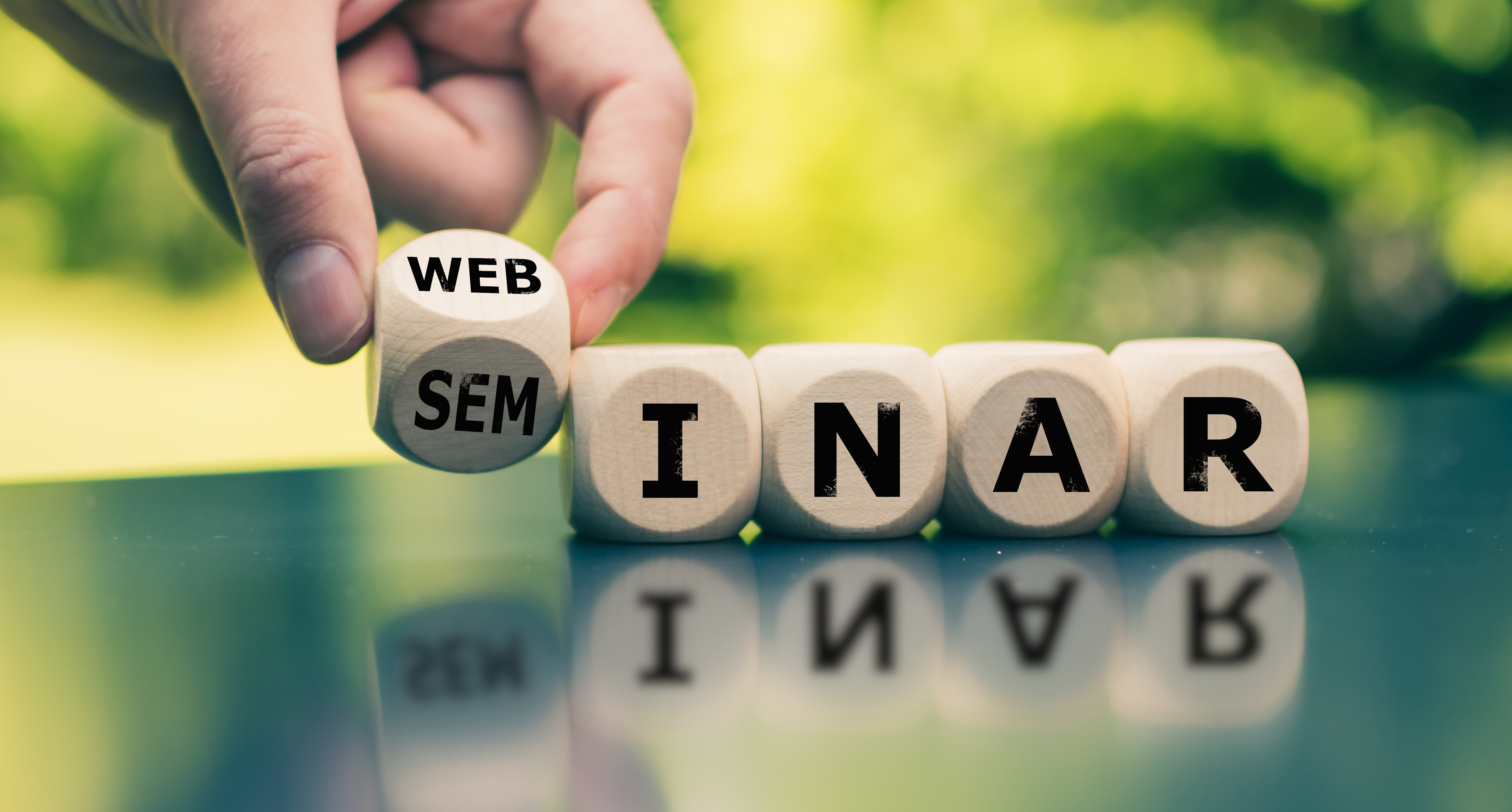 En person som placerar en kub med ordet seminarium på.