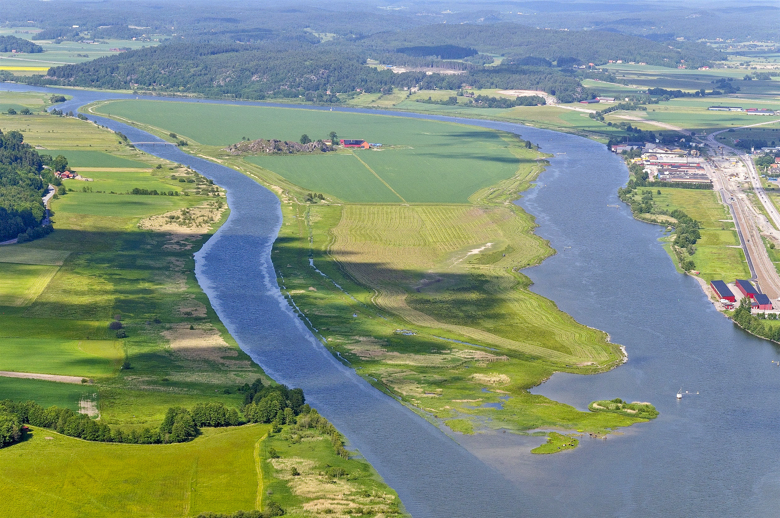 En flod som rinner genom en grönskande landsbygd.