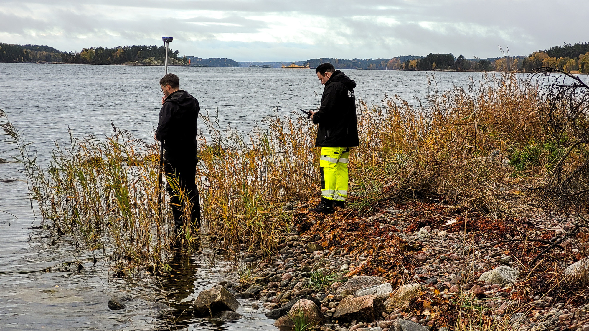 Några män som står bredvid en sjö.