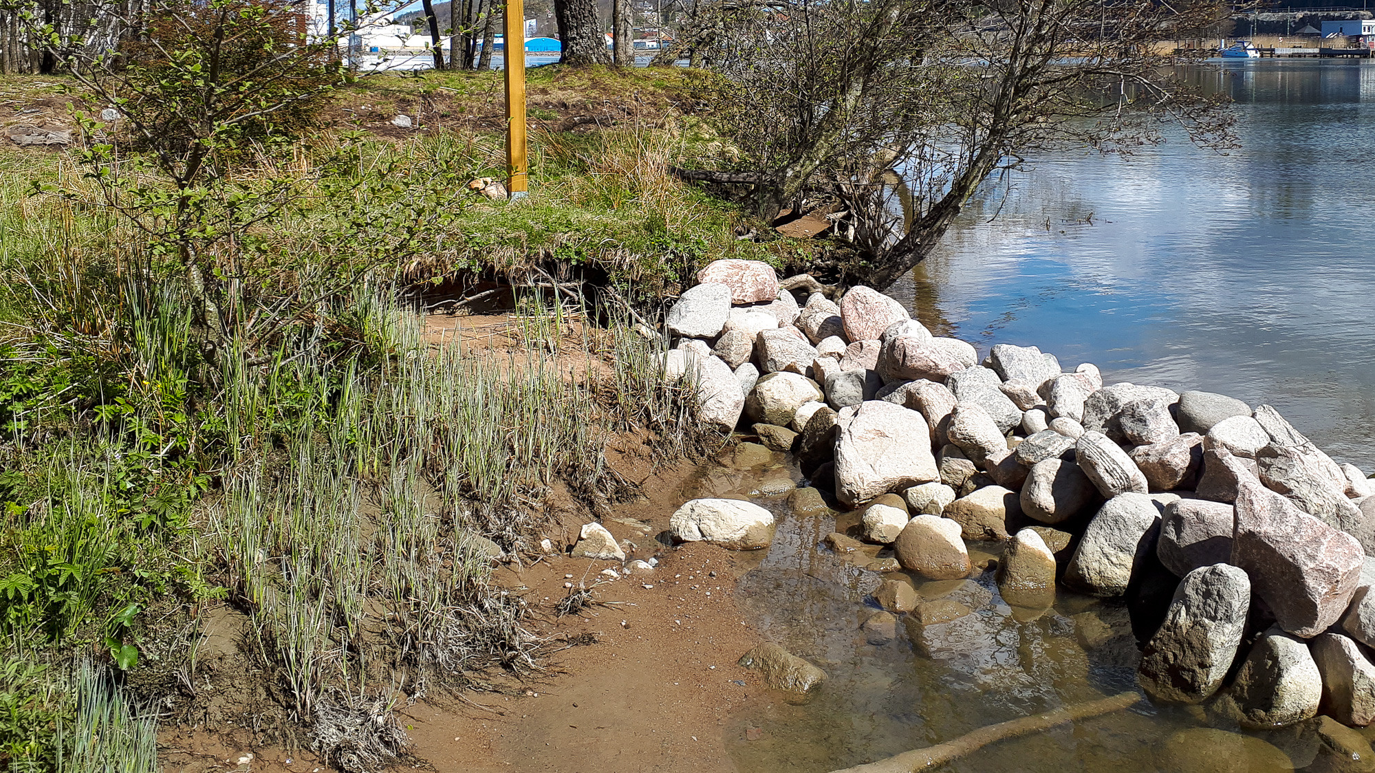En stor klippvägg intill ett vattendrag.