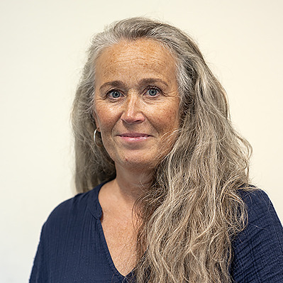 En kvinna med långt hår och blå skjorta.