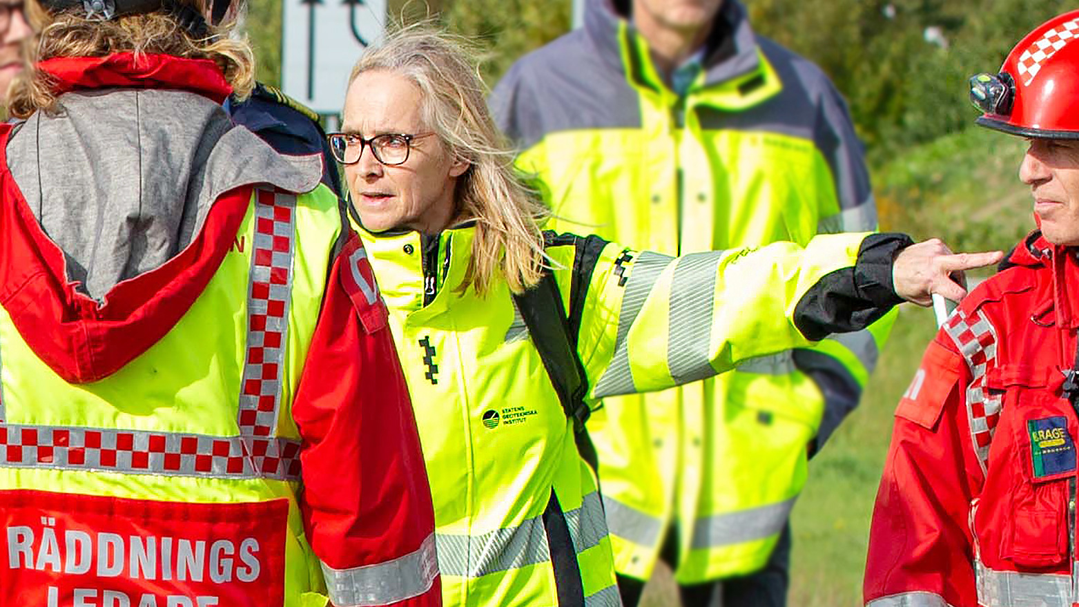 Kvinna i varselkläder pekar