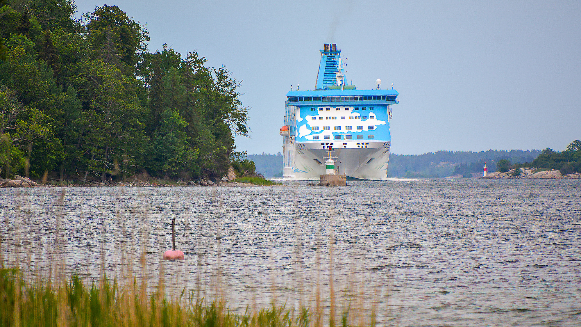 En stor blå och vit båt i ett vattendrag.