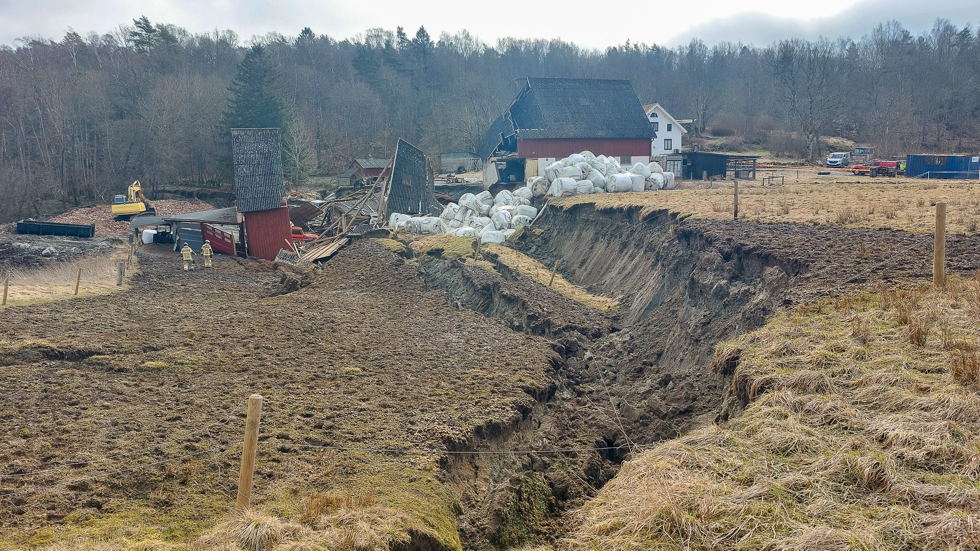 Ett stort öppet fält med ett hus i bakgrunden.