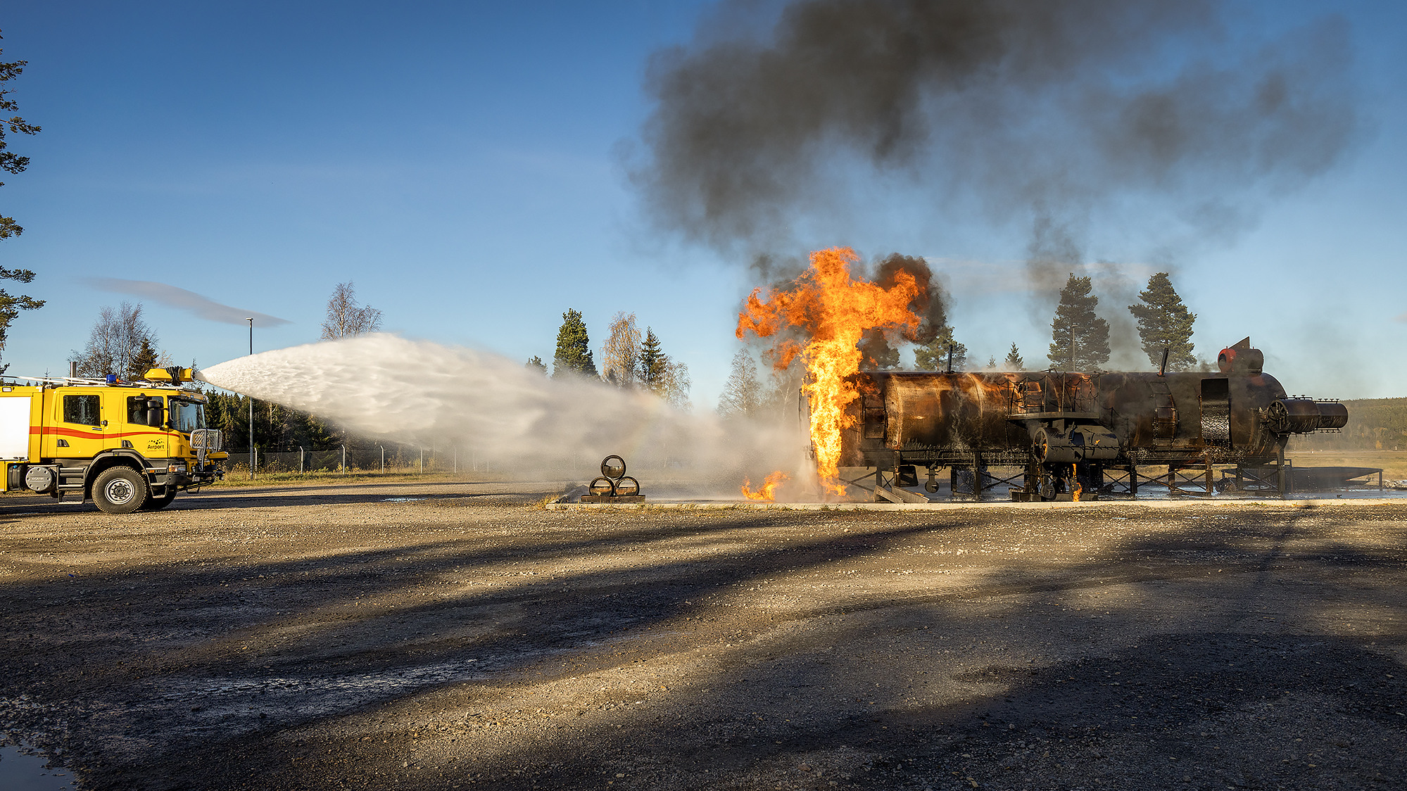 En brandbil som sprutar ut vatten på en järnvägsvagn